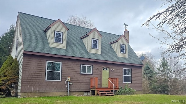 rear view of property featuring a lawn, a shingled roof, and a chimney