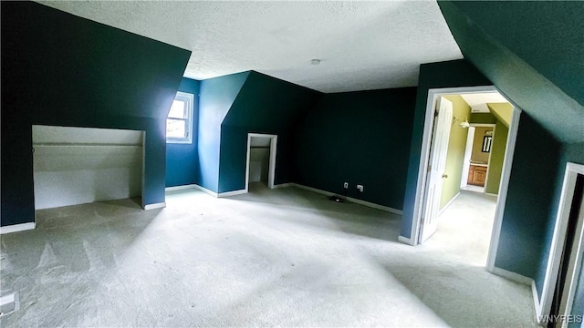 bonus room with carpet, lofted ceiling, and a textured ceiling