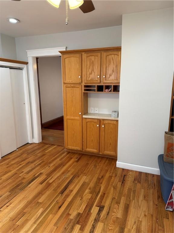 507 W Hudson St, Elmira-City, NY 14904 - kitchen featuring baseboards, brown cabinetry, light wood finished floors, and ceiling fan