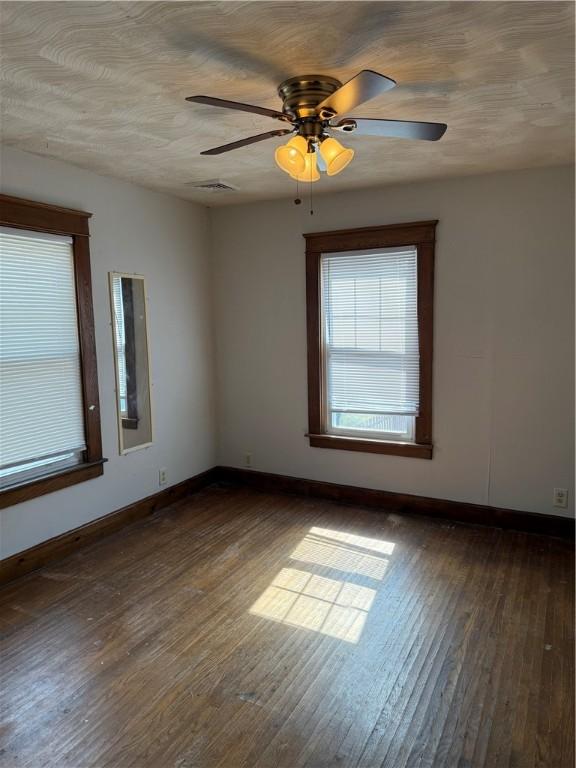 507 W Hudson St, Elmira-City, NY 14904 - unfurnished room featuring baseboards, dark wood-style floors, visible vents, and ceiling fan