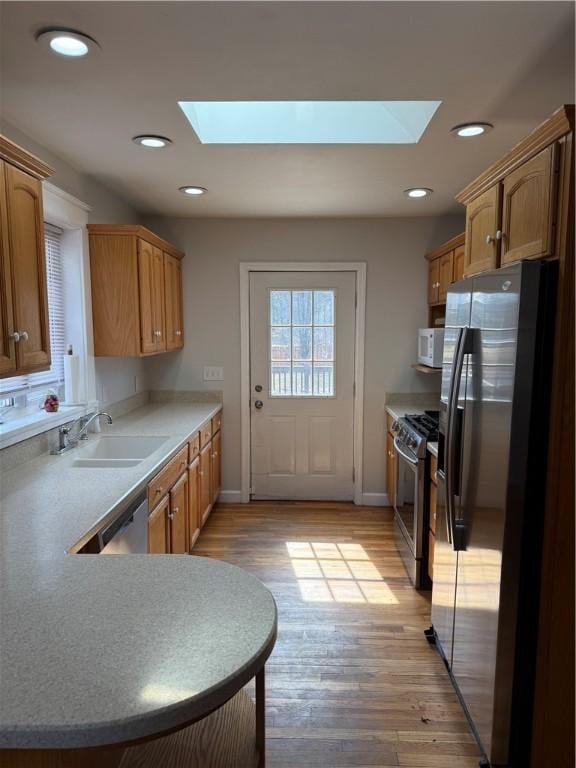 507 W Hudson St, Elmira-City, NY 14904 - kitchen featuring a sink, light wood finished floors, a skylight, appliances with stainless steel finishes, and recessed lighting