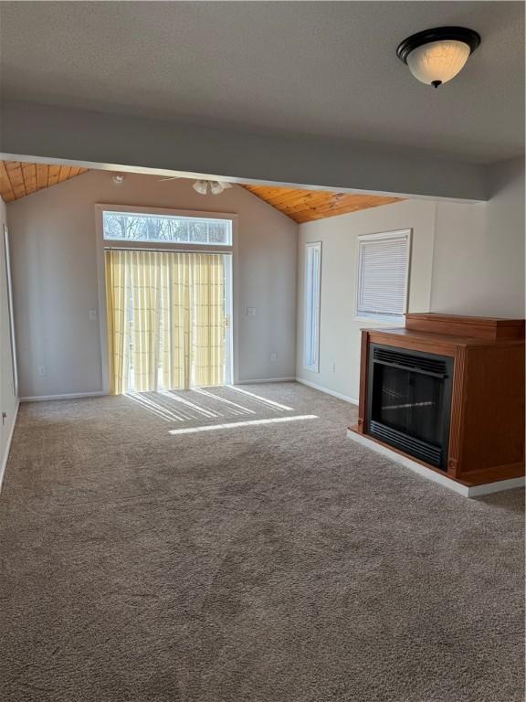 507 W Hudson St, Elmira-City, NY 14904 - unfurnished living room with lofted ceiling with beams, carpet floors, a glass covered fireplace, and a ceiling fan