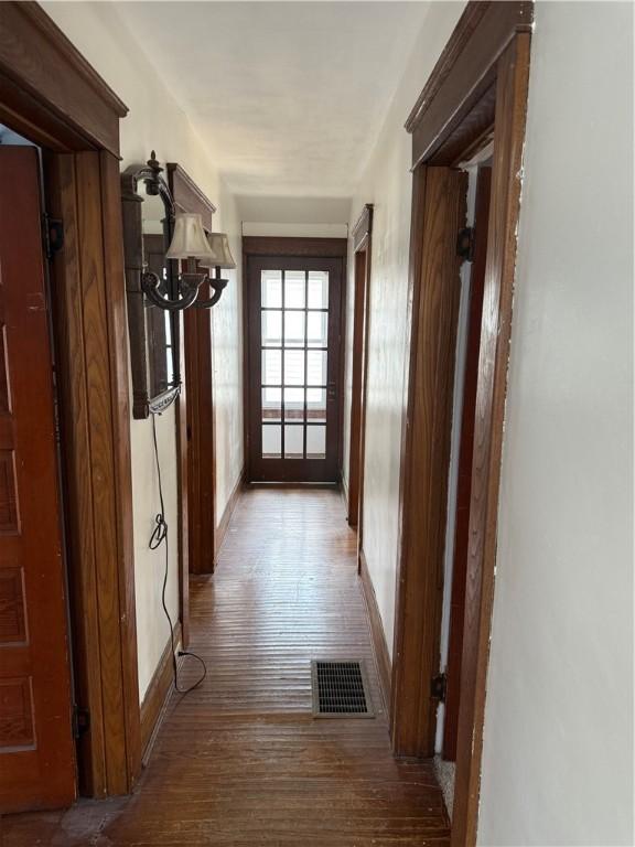507 W Hudson St, Elmira-City, NY 14904 - hall featuring baseboards, visible vents, a notable chandelier, and hardwood / wood-style flooring