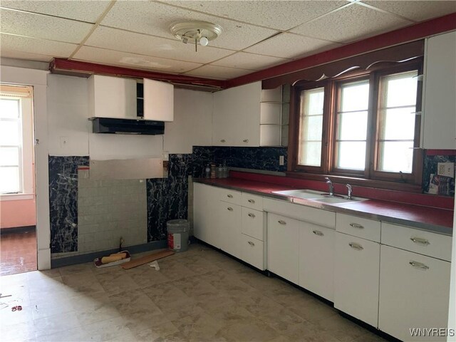 49 Newburgh Ave, Buffalo, NY 14211 - kitchen with a sink, a paneled ceiling, white cabinetry, and under cabinet range hood