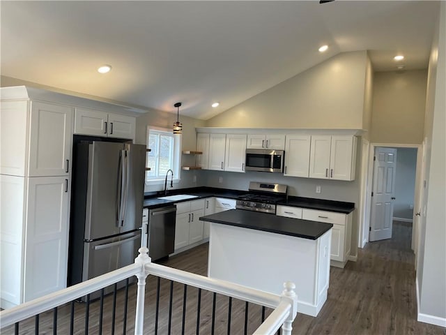 kitchen featuring dark countertops, appliances with stainless steel finishes, white cabinetry, a sink, and dark wood-style floors