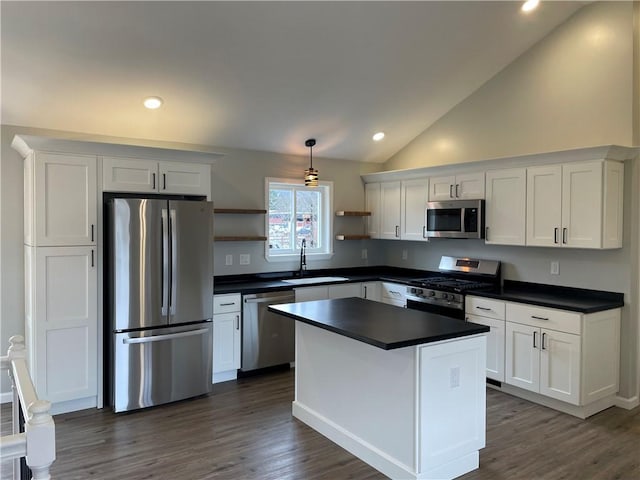 kitchen with white cabinets, stainless steel appliances, dark countertops, a sink, and open shelves