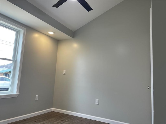 spare room featuring dark wood finished floors, baseboards, vaulted ceiling, and a ceiling fan