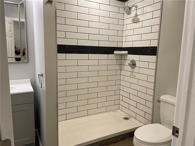 bathroom with a shower stall, toilet, and vanity