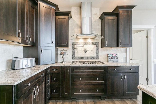5027 Wyffels Rd, Canandaigua-Town, NY 14424 - kitchen featuring wall chimney range hood, tasteful backsplash, stainless steel gas cooktop, wood finished floors, and light stone counters