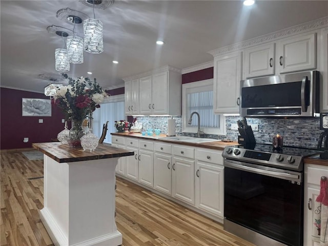 612 Oswegatchie Rd, Palatine, NY 13428 - kitchen featuring wood counters, stainless steel appliances, a sink, crown molding, and white cabinets