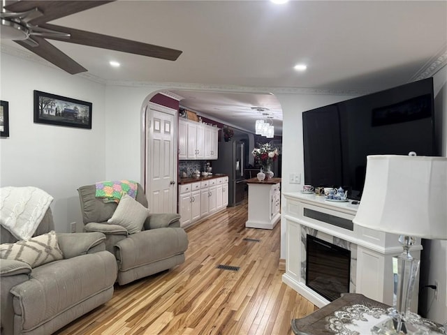 612 Oswegatchie Rd, Palatine, NY 13428 - living area with arched walkways, ornamental molding, ceiling fan, light wood-type flooring, and recessed lighting