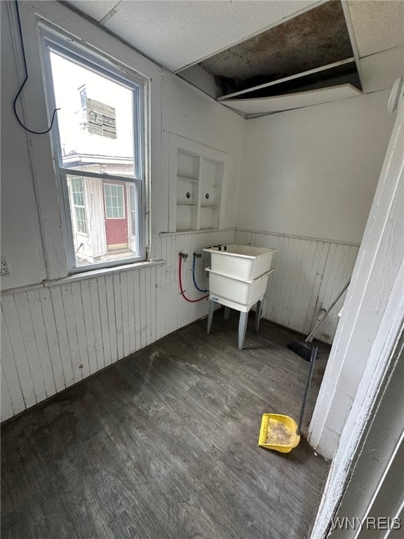 clothes washing area with wainscoting and wood finished floors