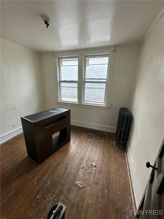 interior space featuring dark wood finished floors, a textured wall, and baseboards