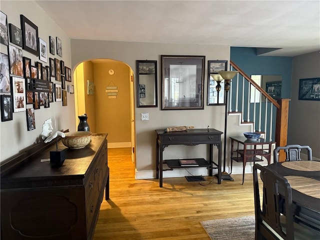 605 Watkins Rd, Horseheads, NY 14845 - dining room featuring light wood-style flooring, arched walkways, baseboards, and stairs