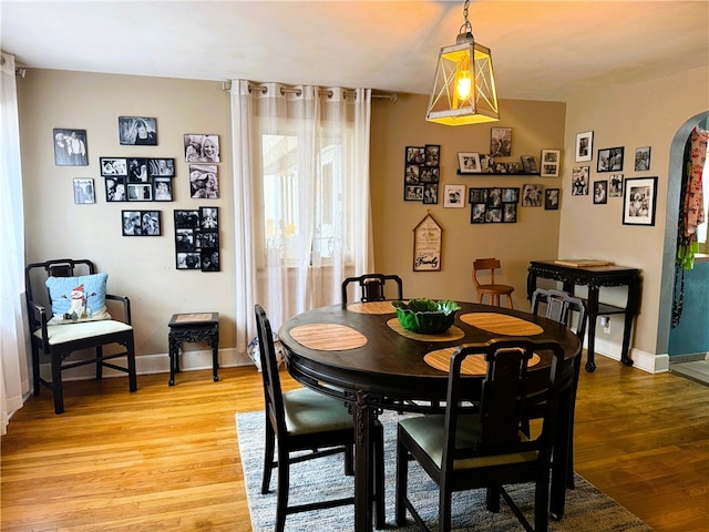 605 Watkins Rd, Horseheads, NY 14845 - dining area featuring arched walkways, baseboards, and light wood-type flooring