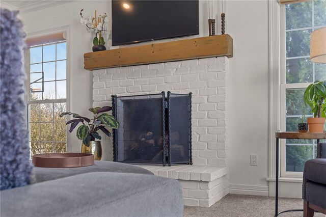 interior details featuring baseboards, a fireplace, crown molding, and carpet flooring
