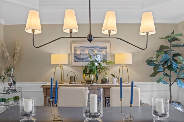 dining area with a wainscoted wall and crown molding