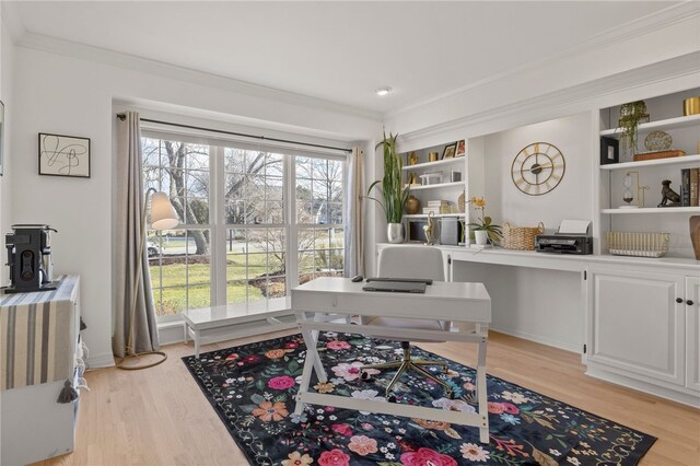 home office with light wood-type flooring and ornamental molding