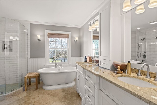 bathroom featuring a shower stall, crown molding, wainscoting, and a sink