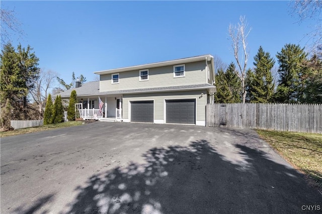 1905 Stump Rd, Skaneateles, NY 13108 - traditional-style house featuring a porch, driveway, fence, and an attached garage