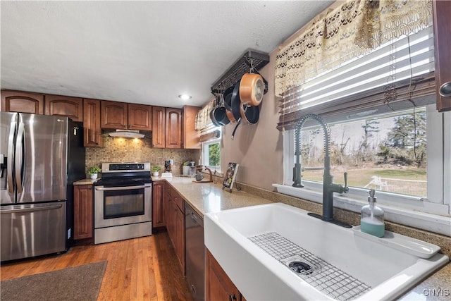 1905 Stump Rd, Skaneateles, NY 13108 - kitchen with light countertops, stainless steel appliances, under cabinet range hood, a sink, and light wood-type flooring