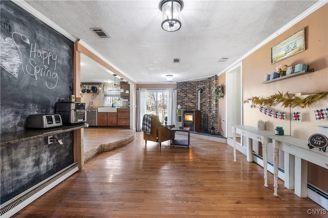 1905 Stump Rd, Skaneateles, NY 13108 - living room featuring ornamental molding, visible vents, a wood stove, and wood finished floors