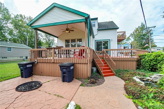 rear view of property featuring fence, a wooden deck, stairs, a ceiling fan, and a patio area
