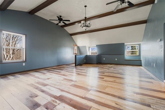 unfurnished living room with hardwood / wood-style floors, a ceiling fan, vaulted ceiling with beams, and a wealth of natural light