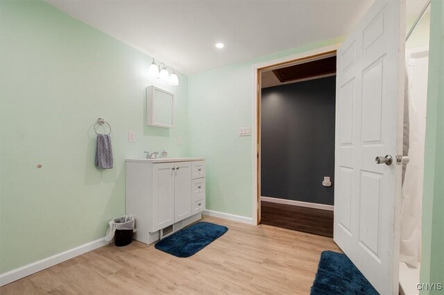 full bathroom with baseboards, recessed lighting, wood finished floors, and vanity