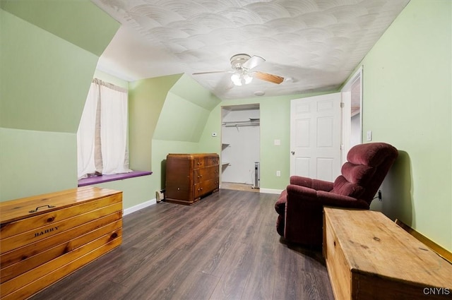 sitting room featuring a ceiling fan, dark wood-style flooring, baseboards, and vaulted ceiling