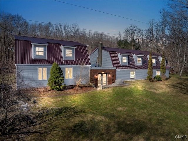 dutch colonial featuring metal roof, a chimney, a front lawn, and a gambrel roof