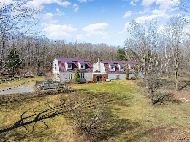 dutch colonial with a gambrel roof, a front yard, driveway, and metal roof