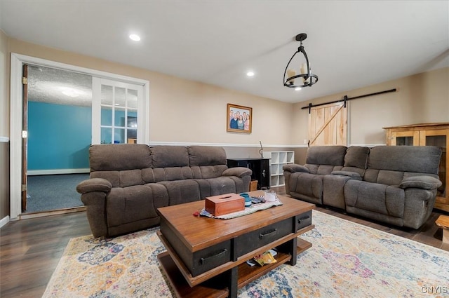 living room featuring baseboards, a barn door, wood finished floors, and recessed lighting