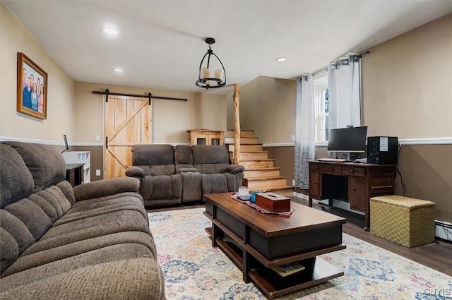 living area featuring stairway, a barn door, wood finished floors, and recessed lighting