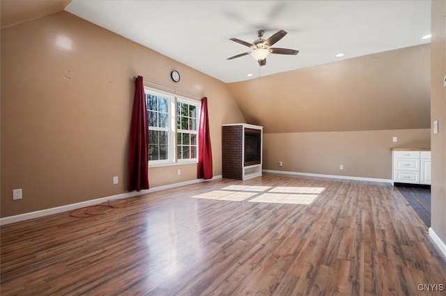 additional living space with baseboards, vaulted ceiling, wood finished floors, and ceiling fan