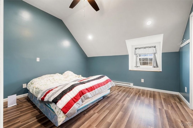 bedroom with baseboards, a baseboard heating unit, and wood finished floors
