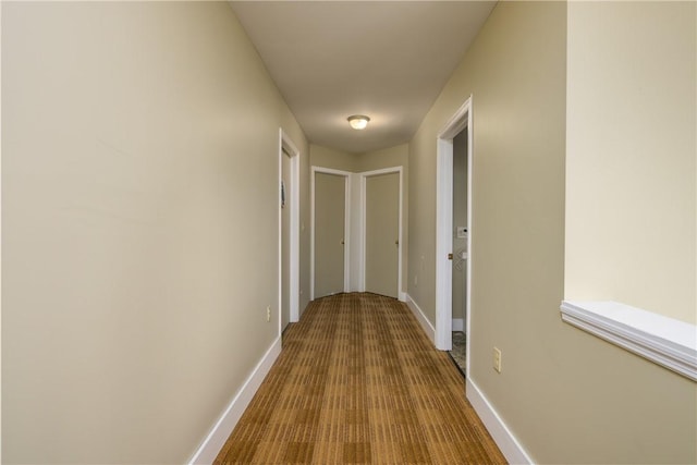 hall with baseboards and dark wood-style flooring