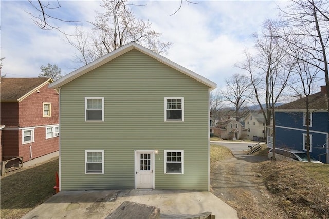 rear view of property featuring aphalt driveway and a patio area