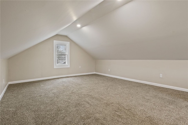 additional living space with baseboards, carpet flooring, and lofted ceiling