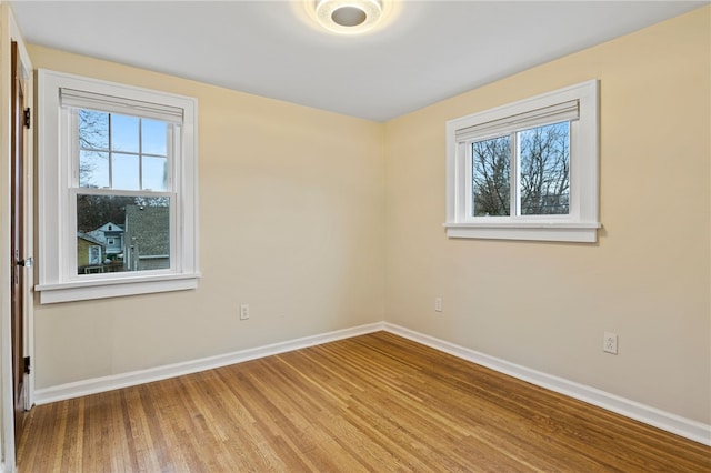unfurnished room featuring baseboards and wood finished floors