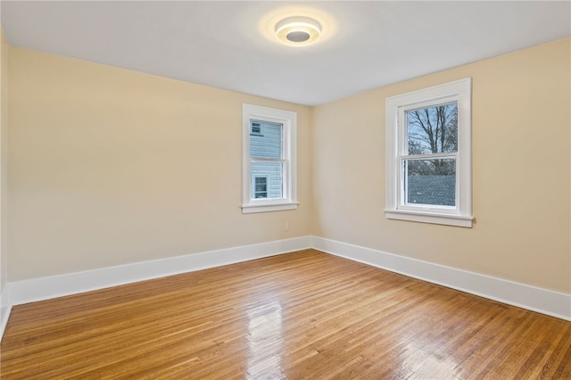 unfurnished room with light wood finished floors and baseboards