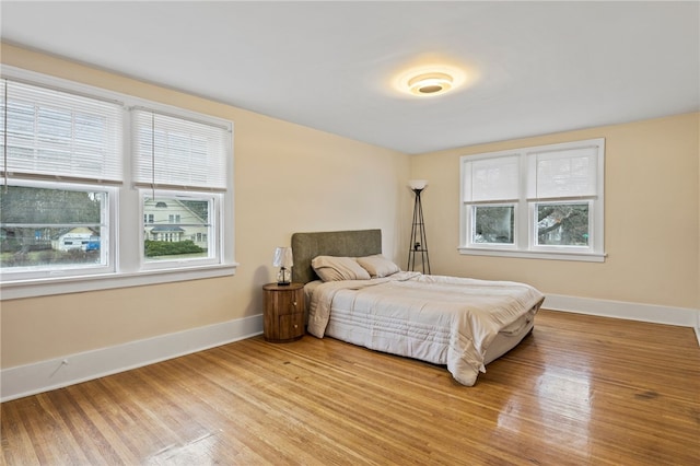 bedroom with baseboards and wood finished floors