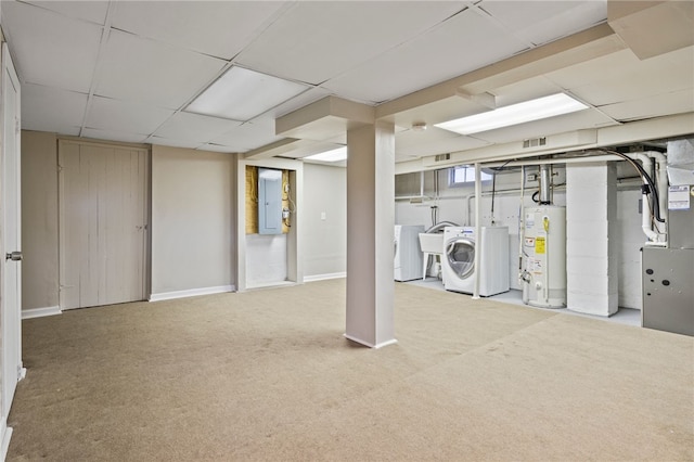 below grade area with water heater, washing machine and dryer, baseboards, carpet, and a drop ceiling