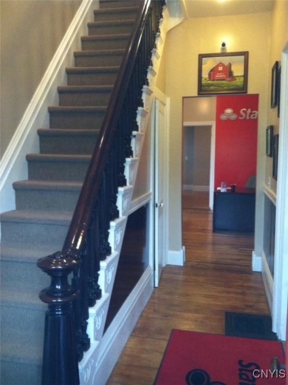 staircase with baseboards and wood finished floors