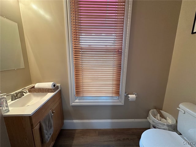 bathroom with toilet, vanity, and baseboards