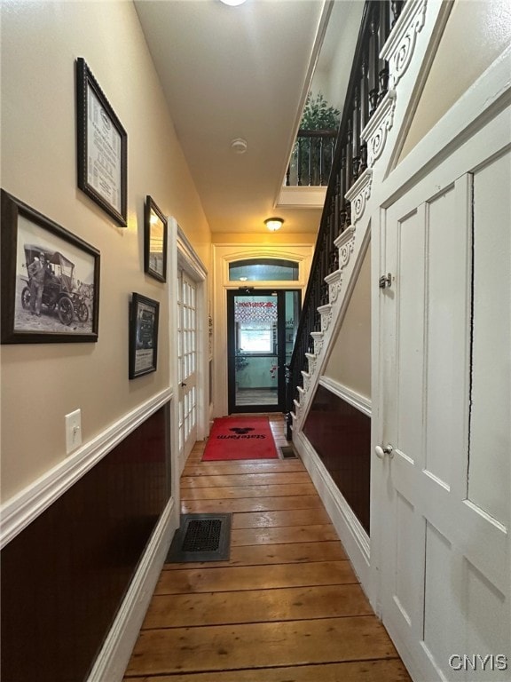 doorway featuring wood-type flooring, stairway, and visible vents
