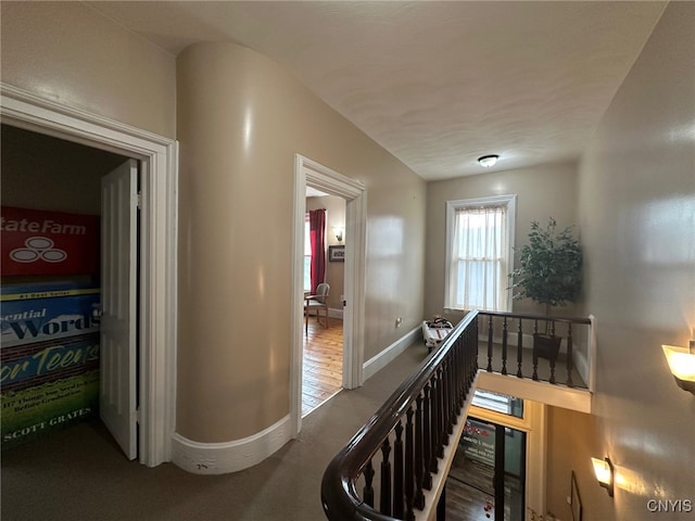 hallway featuring baseboards and an upstairs landing