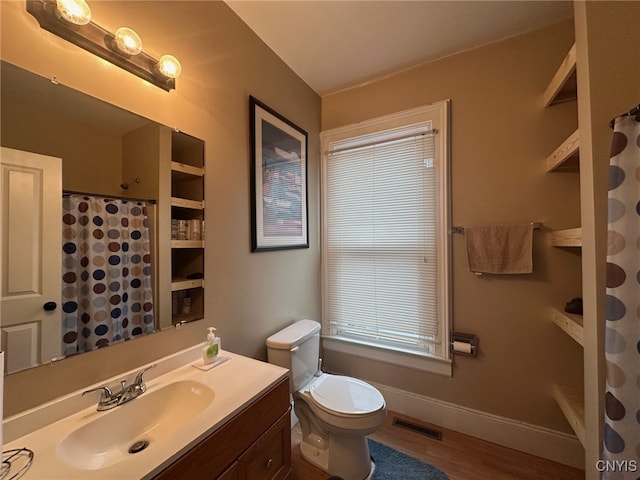 bathroom with vanity, visible vents, toilet, wood finished floors, and baseboards