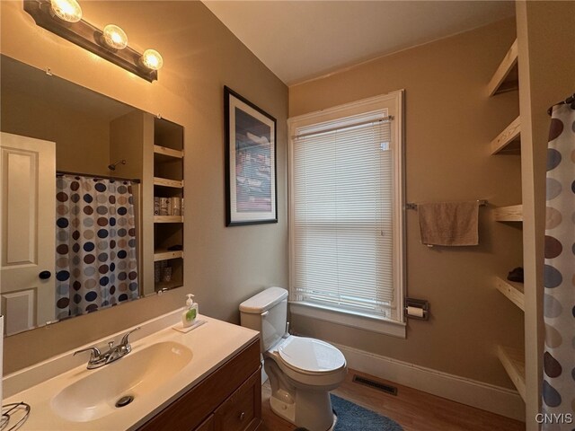 205 W Main St, German Flatts, NY 13357 - bathroom featuring vanity, toilet, wood finished floors, curtained shower, and baseboards