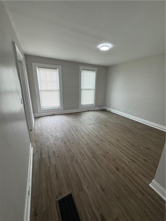 317 W State St, Albion, NY 14411 - empty room featuring dark wood finished floors and baseboards